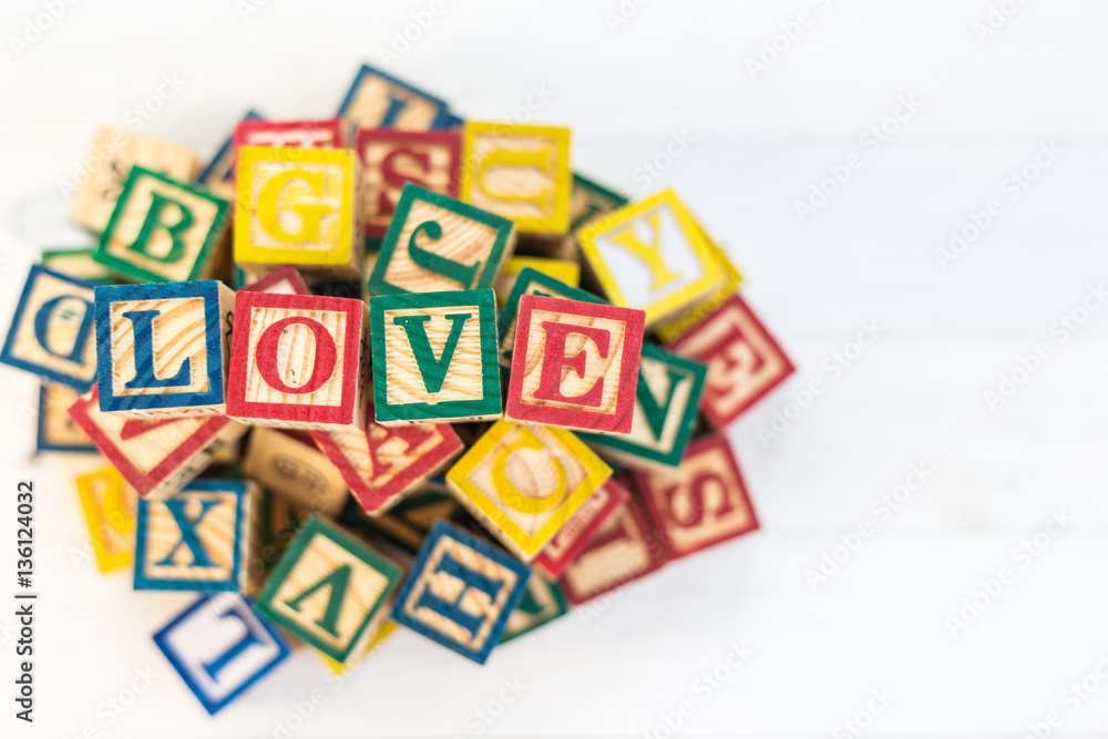 LOVE write in wooden alphabet block on white wooden background. LOVE write in wooden alphabet block on white wooden background.