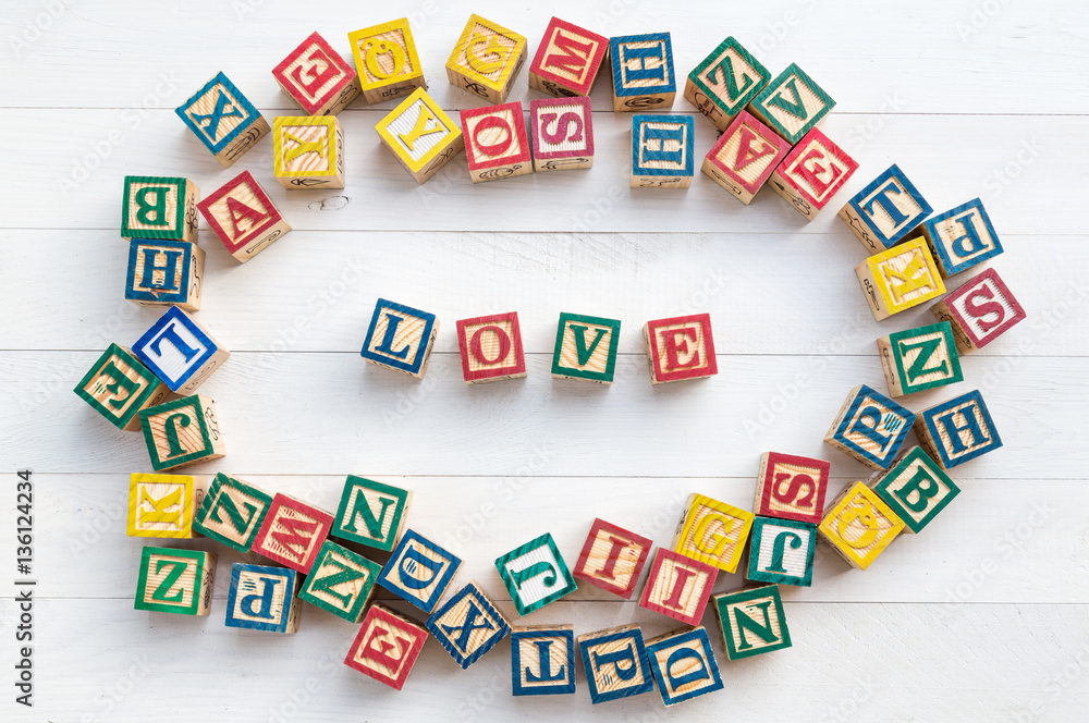 LOVE write in wooden alphabet block on white wooden background. LOVE write in wooden alphabet block on white wooden background.