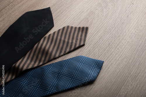 Silk neck ties on wooden background.
