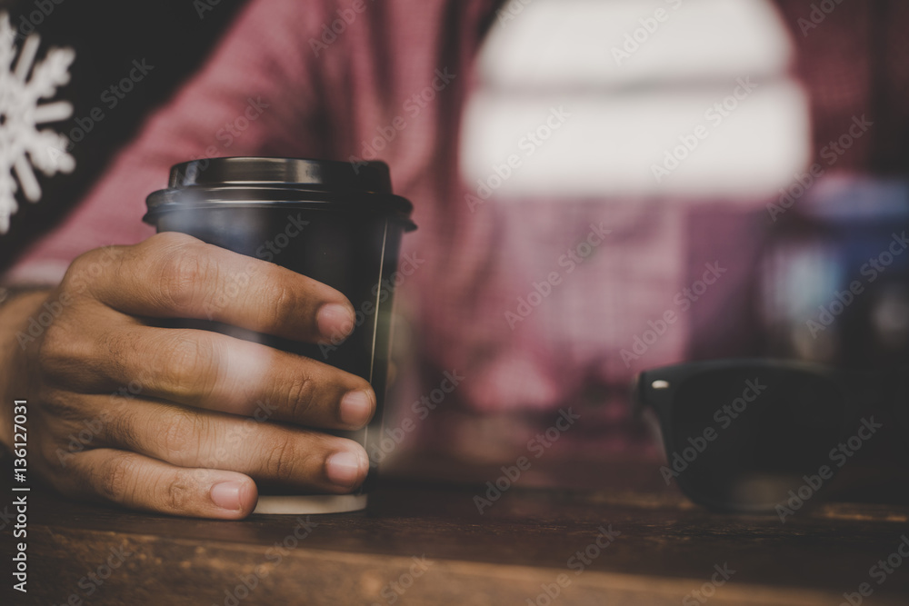 Hipster man holding a cup of coffee and sitting on cafe bar. Hipster man holding a cup of coffee and sitting on cafe bar.