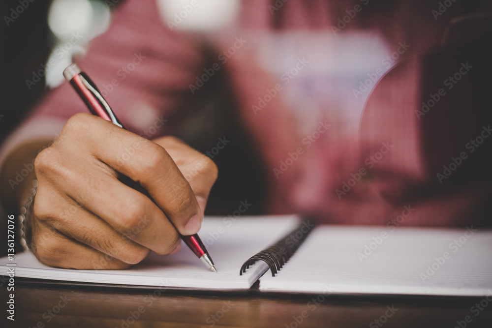 Hipster right hand writing on notebook in morning time. Hipster right hand writing on notebook in morning time.