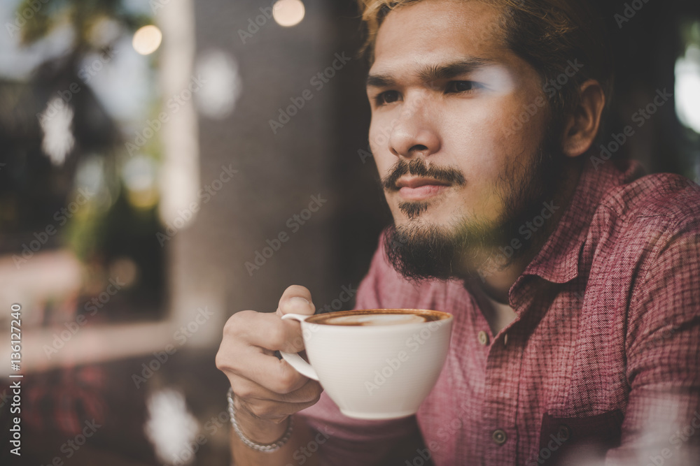 Young man looking away while sitting at the bar in cafe. Young man looking away while sitting at the bar in cafe.
