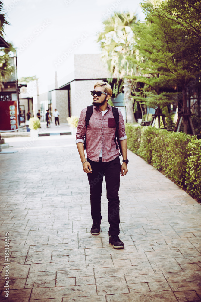Portrait of handsome hipster man in jeans clothes and sunglasses.