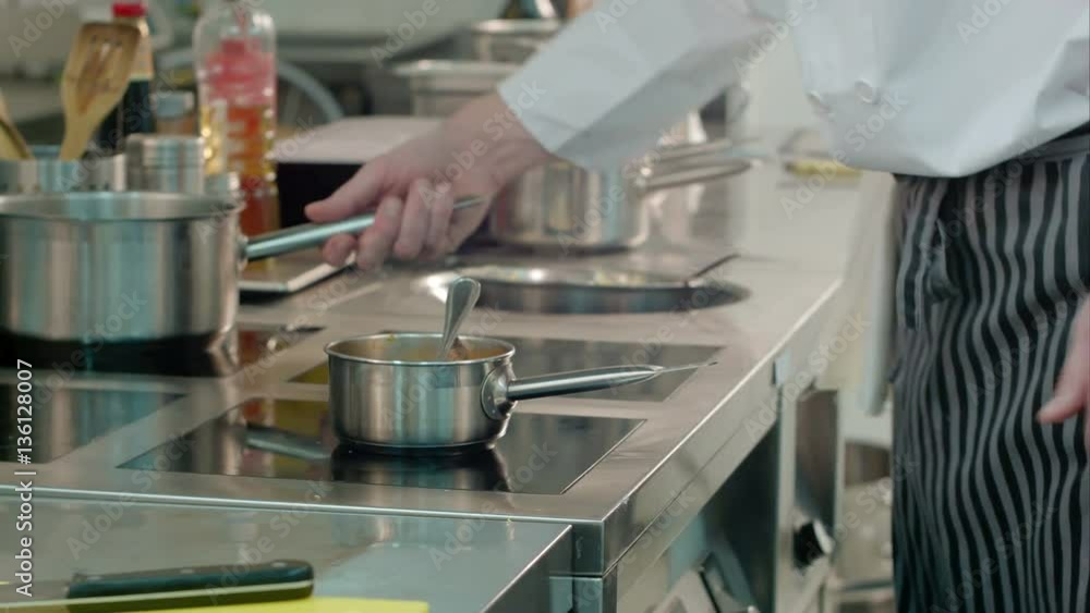 Chef male hands checking meals being cooked on the stove Chef male hands checking meals being cooked on the stove
