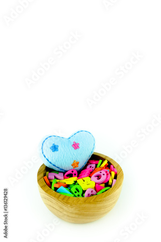 Blue heart and colorful letters in wooden bowl