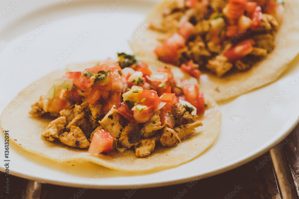 Tacos de carnitas y carne al pastor, comida Mexicana con tortillas.