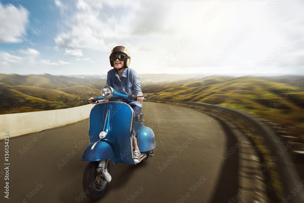 Fototapeta premium Young asian woman riding motor scooter with helmet