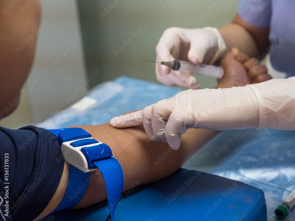 nurse with syringe is taking blood for test at the laboratory