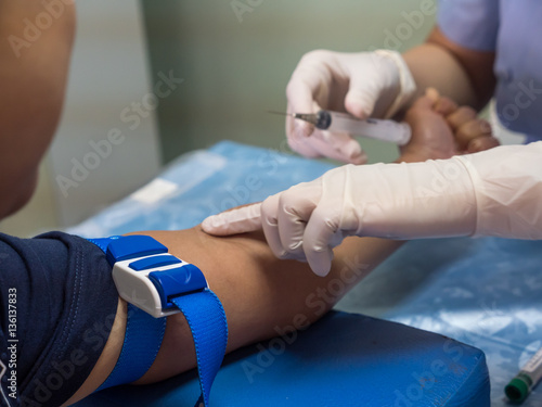 nurse with syringe is taking blood for test at the laboratory