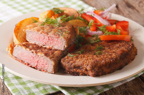 Fried Breaded rump steak with potato and vegetables close-up. horizontal