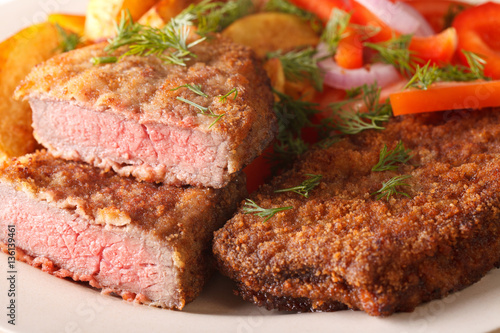 rump steak in breadcrumbs and garnished with vegetables macro horizontal
