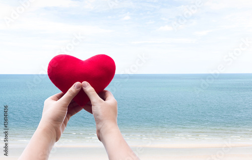 Hand with heart shape and beautiful sea and clean sky