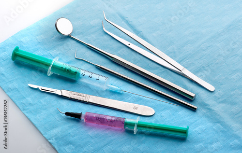 diverse Instrumente in der Zahnarztpraxis liegen auf Operationstuch
