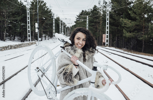 Smiling lady with bike on railroad photo