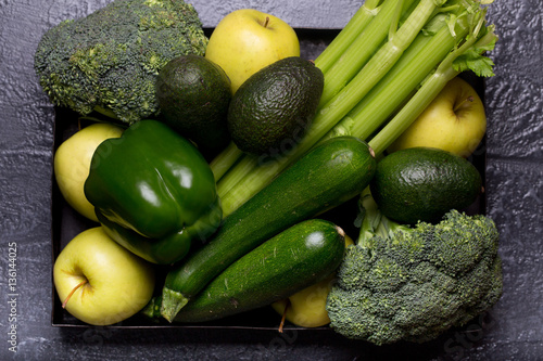 Food background of green vegetables broccoli romaine lettuce celery pepper zucchini on black table Healthy lifestyle Top view Copy space