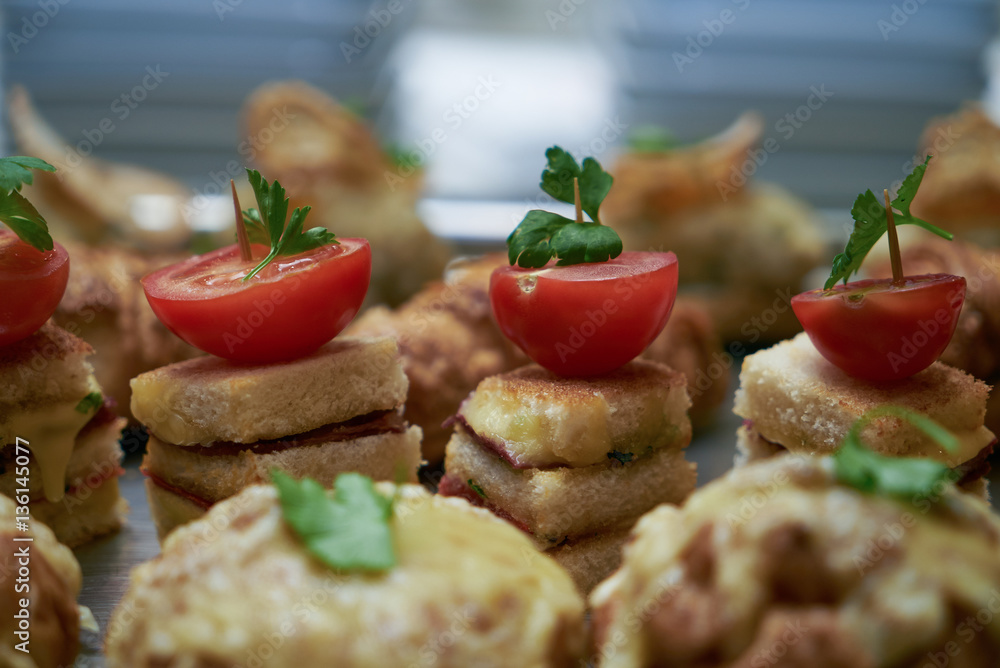Canapes with stuffed cherry tomatoes on an wooden buffet table.Close up.