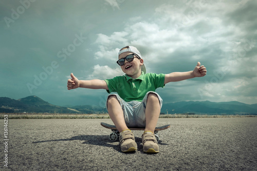 Child with skateboard under sunlight. © Andrii IURLOV