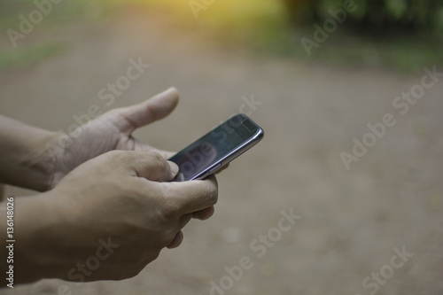 Close up of a man using mobile smart phone outdoor, in hand