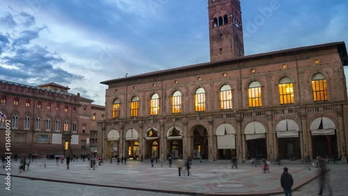King Enzo palace at the main square of Bologna, Italy. Famous landmark at sunset at night. Time-lapse, tracking shot