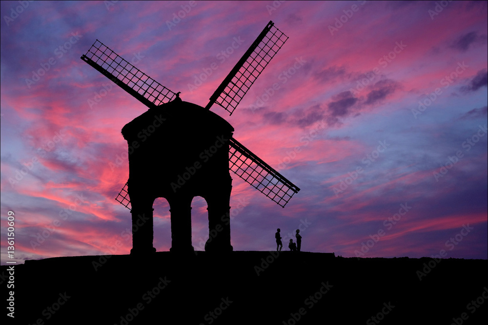 Old windmill set against late evening sky. Photographic montage.