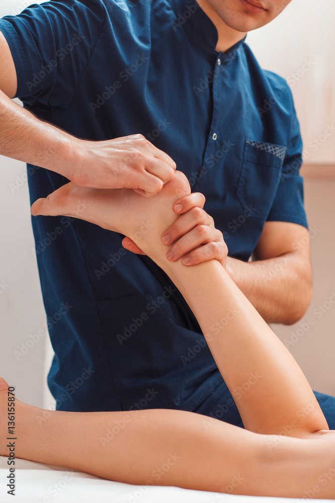Man massaging female feet close up. Unrecognizable masseur making relaxing exercises for perfect woman leg, free space. Body care, health, beauty, alternative medicine concept