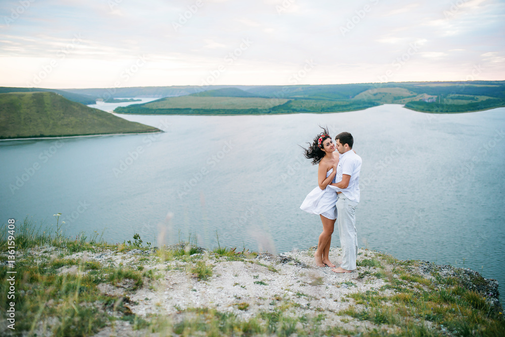 Loved couple in love at amazing landscape against cliff rocks.