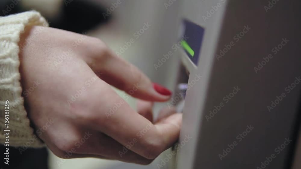 Woman's hand with painted red nails inserting credit card to ATM. Beautiful manicure Woman's hand with painted red nails inserting credit card to ATM. Beautiful manicure