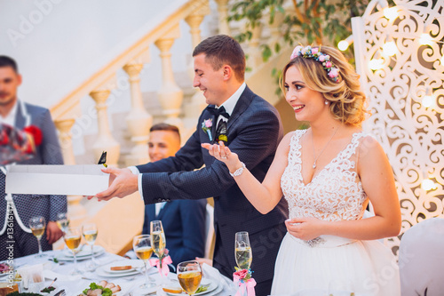 Obraz na płótnie Newlyweds get an original gift butterfly from mother. Shocked and smiling bride. Groom emotions. w salonie