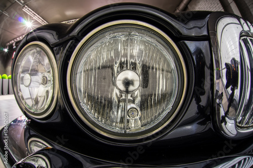 Close up high detailed view on headlights of black retro luxury car. © Media_Works