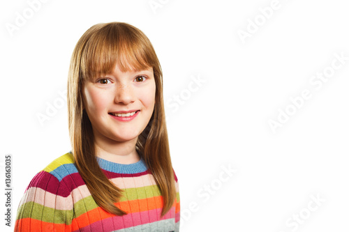 Studio shot of young little 9-10 year old girl, wearing colorful pullover, white background