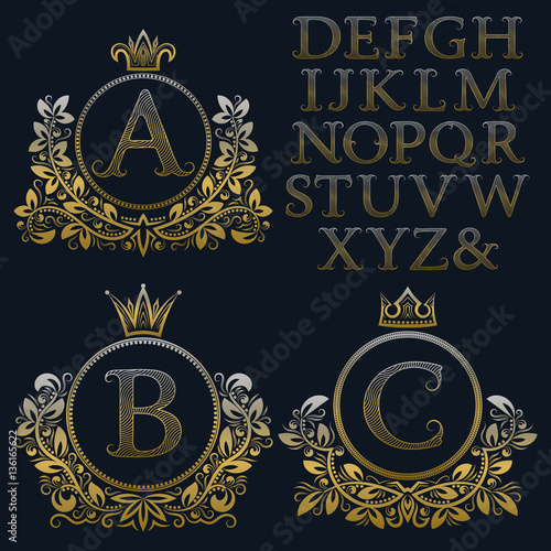 Vintage monogram kit. Golden patterned letters and floral coat of arms frames for creating initial logo in antique style.
