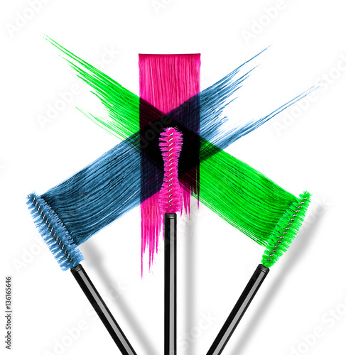 Strokes of colored mascara with brushes close-up on white backgr