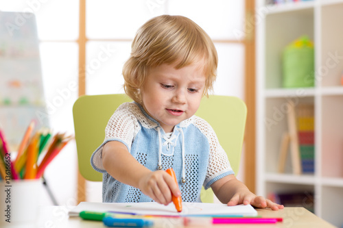 Kid little boy paints in hi...