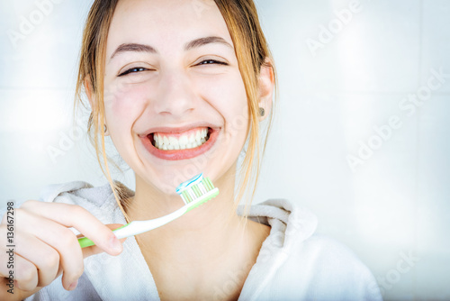 Fototapeta Naklejka Na Ścianę i Meble -  Happy young woman brushing teeth .