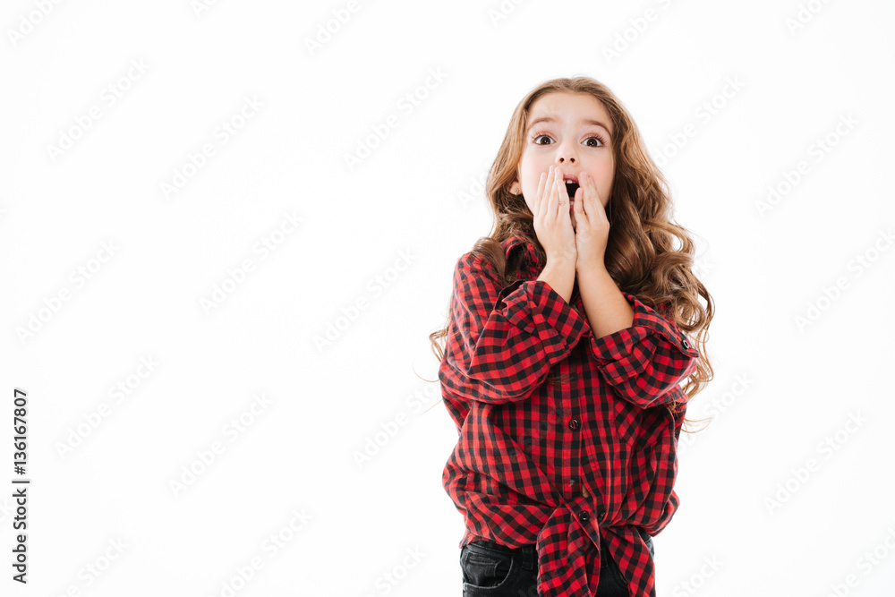 Surprised curly little girl covered opened mouth by hands Surprised curly little girl covered opened mouth by hands