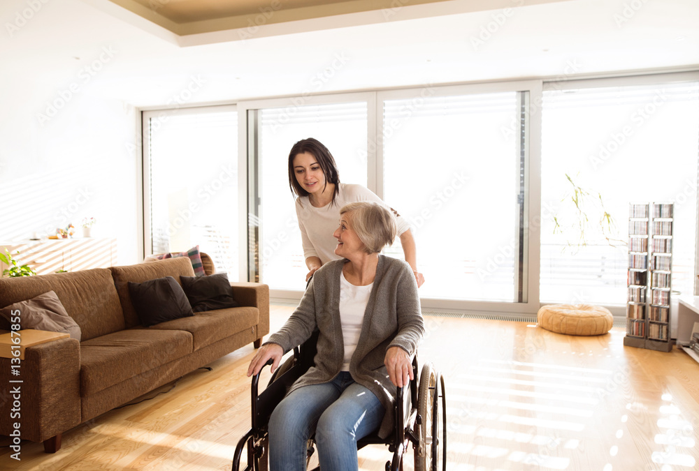 Disabled senior woman in wheelchair with her young daugher. Disabled senior woman in wheelchair with her young daugher.