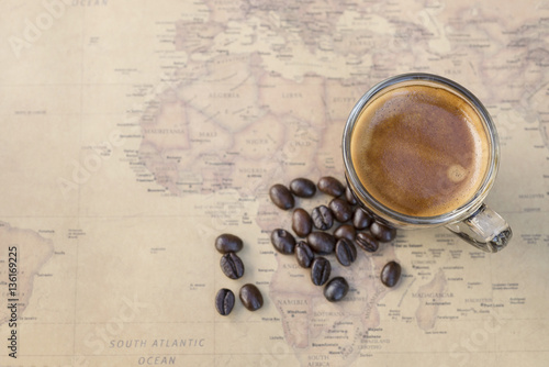 Black coffee with bean on world map background