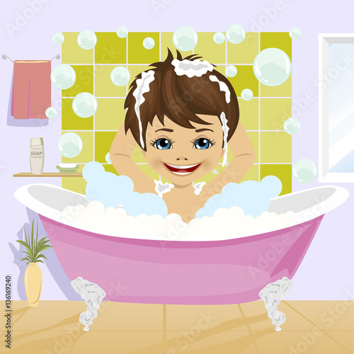 little boy washing his hair with shampoo sitting in bathtub in bathroom
