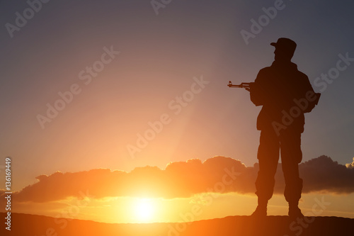 silhouette of a soldier with a gun in the sunset