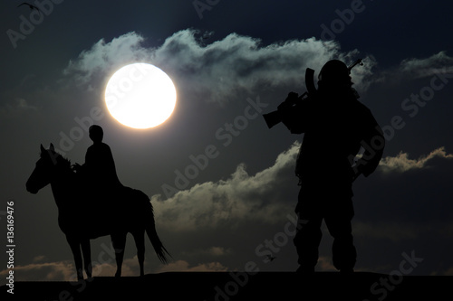 silhouette of military man on a horse on sunset background © YURII Seleznov
