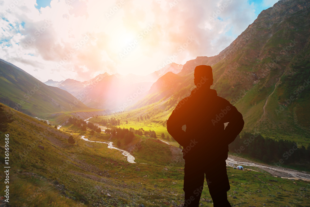 man against the sea standing on a mountain top looking into the distance