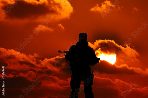 silhouette of a soldier with a gun in the sunset