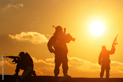 three silhouette of a soldier on a beautiful background