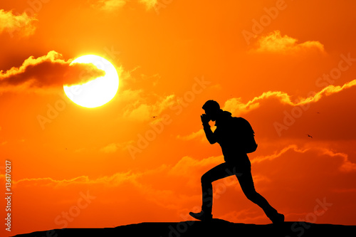 Fototapeta Naklejka Na Ścianę i Meble -  Man runs directly on a hill against a beautiful sunset