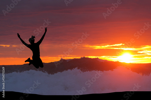 beautiful silhouette of a girl jumping at sunset