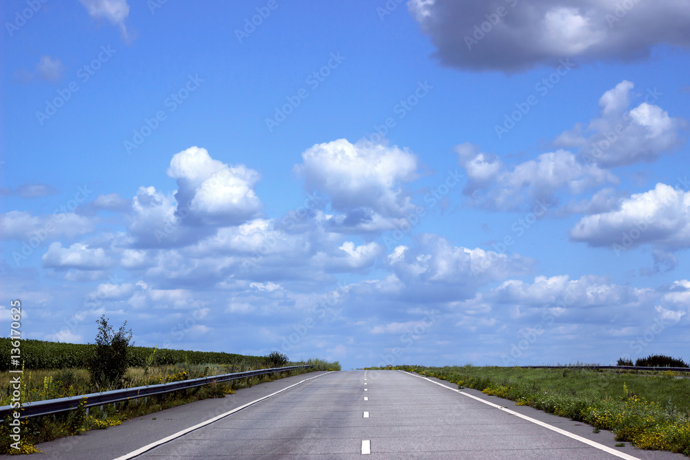 Asphalt road over blue sky background.