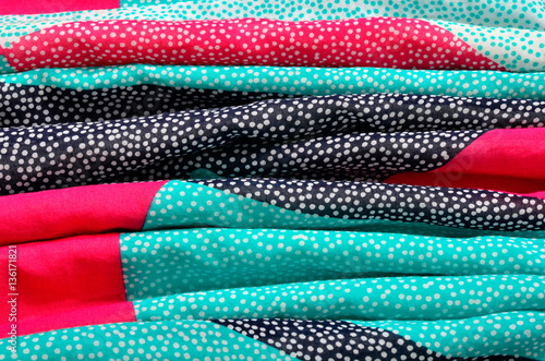 Polka dots on colored folded fabric as background.