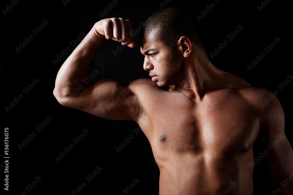 Obraz premium Handsome shirtless african american fitness man standing and showing biceps