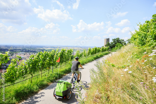 Young Parent Cycling With Bike Trailer