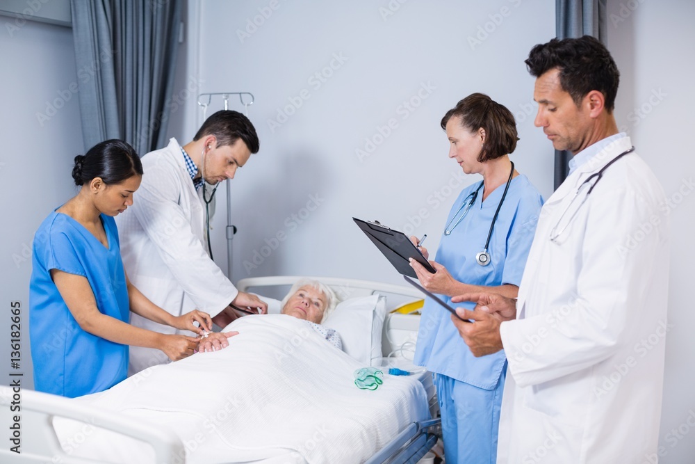 Doctors examining patient in ward Doctors examining patient in ward